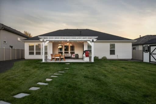 white house with white pergola and red BBQ grill