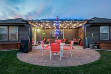 tan house with tan pergola and red patio furniture in Boise, Idaho.