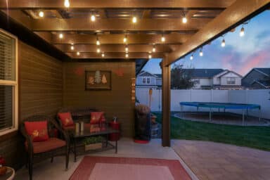 tan house with tan pergola and red patio furniture in Boise, Idaho.