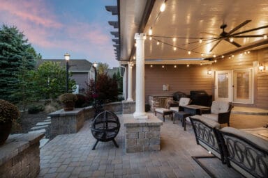 tan patio cover with white columns and pink potted flowers in Boise, Idaho.