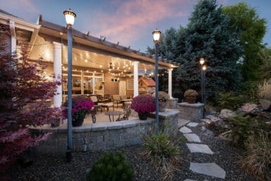 tan patio cover with white columns and pink potted flowers in Boise, Idaho.