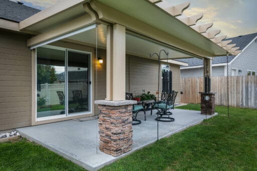 tan patio cover with blue and black patio furniture in Boise, Idaho.