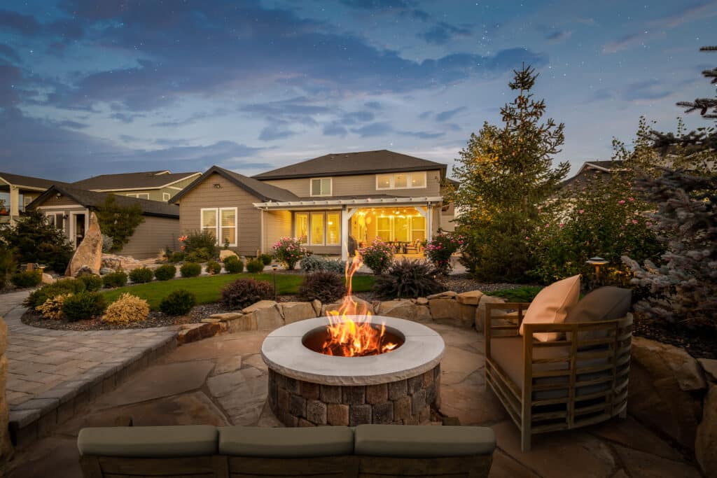 white patio cover on grey concrete patio with fire pit and string lights in the evening